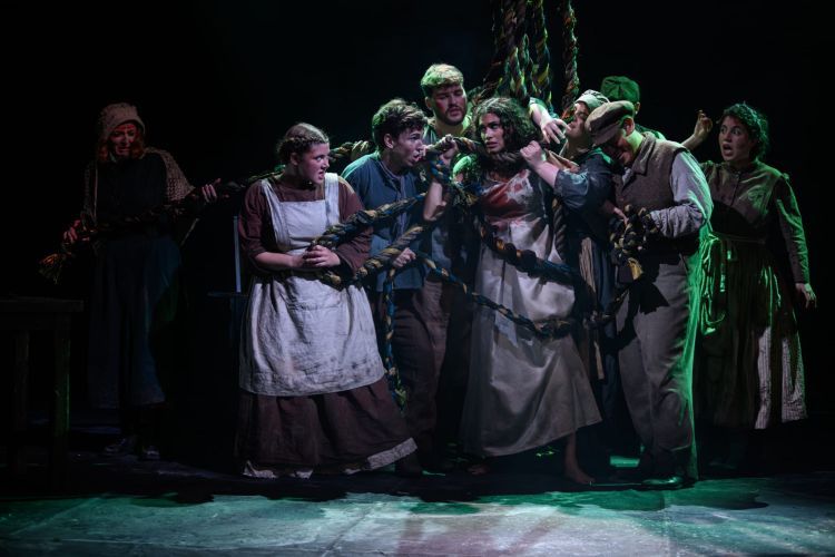 Ensemble in working class Victorian style clothes all tangled up in a thick twisted rope
